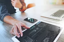 employee working with digital tablet and computer laptop smart phone on wooden desk