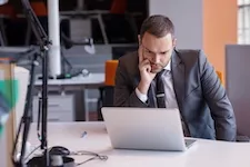 frustrated young business man working on laptop computer
