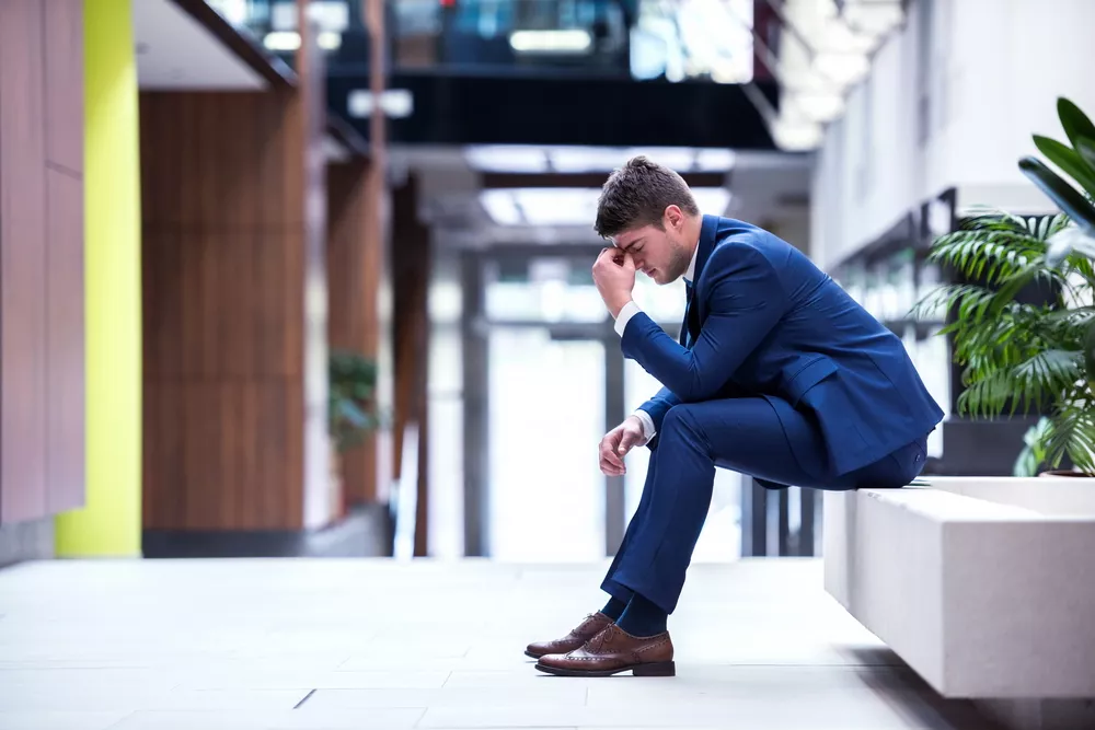 frustrated young business man holding head in hands